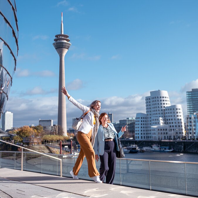 Two happy people pose for a photo in Düsseldorf's Medien Hafen. | © Düsseldorf Tourismus – EU React