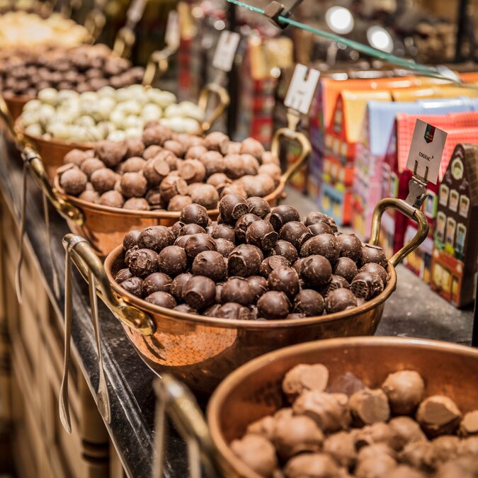Belgian chocolates and truffles in copper pots on a sales counter in Bruges. | © Pieter D'Hoop – Bruges chocolates