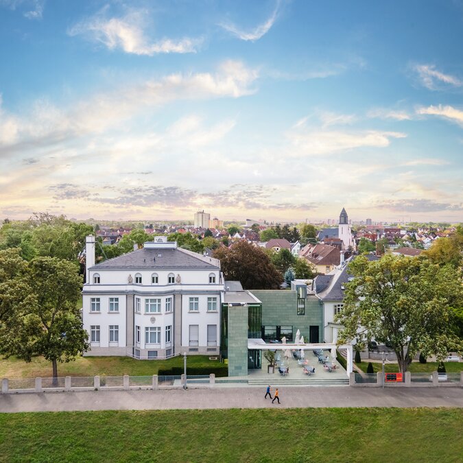 A white villa in the foreground, the skyline of a small town in the background. | © #visitrheinmain | David Vasicek