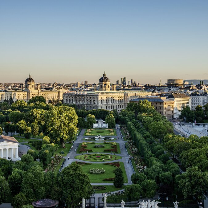 Vue panoramique du centre-ville de Vienne avec le Volksgarten et les bâtiments historiques du musée dans la lumière du soir. | © Wien Tourismus | Christian Stemper