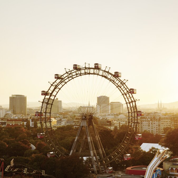 Das Riesenrad auf dem Prater mit der Skyline von Wien im Hintergrund in der Abenddämmerung.  | © Wien Tourismus | Peter Rigaud