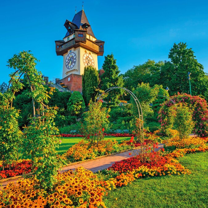 Tour de l'horloge dans un jardin fleuri | © Shutterstock 478097368