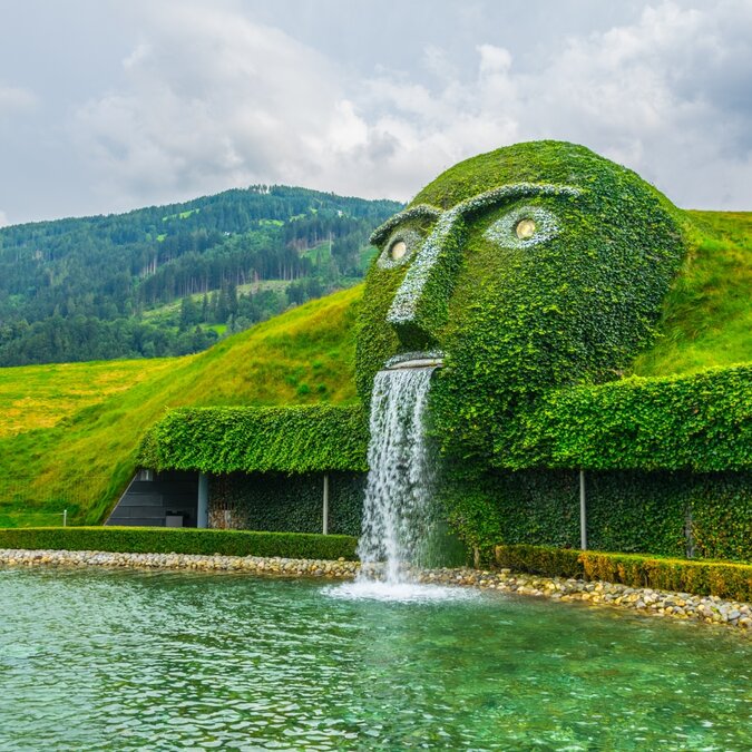 Fountain with giant head spitting water into a pond at Swarovski Crystal Worlds in Wattens | © Shutterstock 552829036