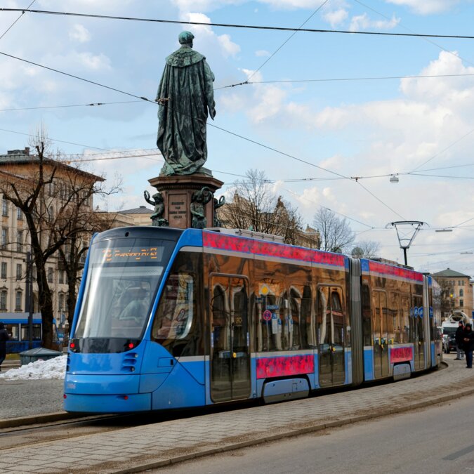 Scenery of a metro tram stopping before the statue of King Maximalian on a sunny winter day, at a beautiful street corner in Munich City | © Shutterstock 1559941772