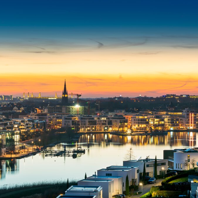 View of Dortmund’s Phoenix Lake with illuminated skyline and Florian Tower at sunset
 | © shutterstock_2166007865