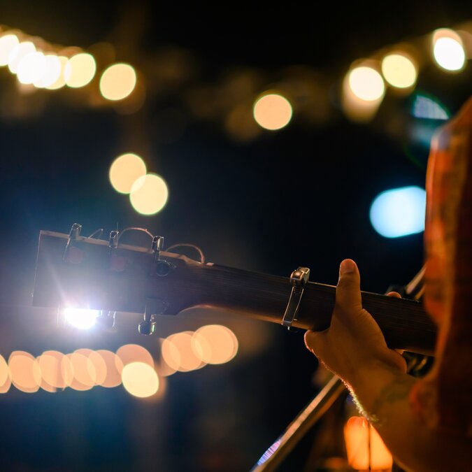 Gitarrenspieler von hinten bei stimmungsvollem Licht | © shutterstock / 1505795255