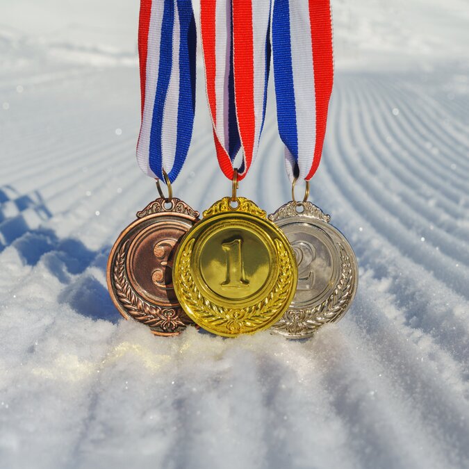 Olympic medals in the snow | © shutterstock / 2412289739