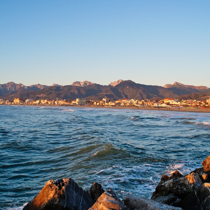Blick vom Wasser an die Küste in Viareggio im Abendlicht | © shutterstock / 2280391541