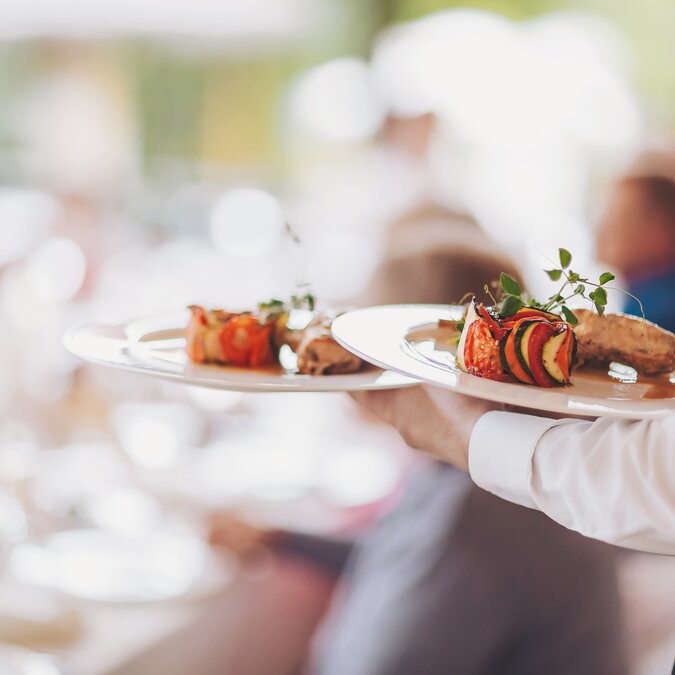 Service brings elegantly arranged plates in a good restaurant | © shutterstock / 2542864127